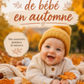 Bébé souriant assis dans des feuilles d'automne colorées.