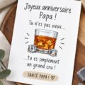 Carte d'anniversaire humoristique pour un père amateur de whisky, blanche et colorée avec des motifs amusants.