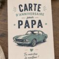 Une belle carte d'anniversaire faite main pour papa sur une table décorée.